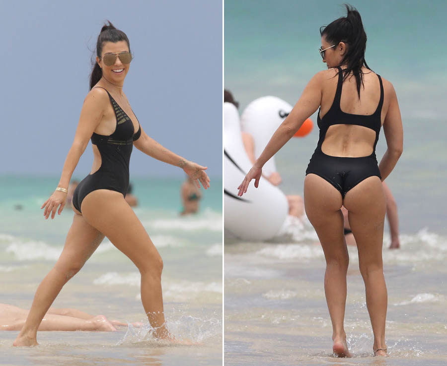 Kourtney Kardashian wears a plunging black one piece swimsuit in Miami Beach