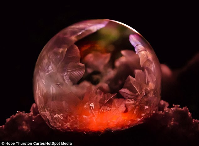 Inner glow: A                                                    mysterious-looking red                                                    light shines from                                                    within this bubble of                                                    frozen soapy water