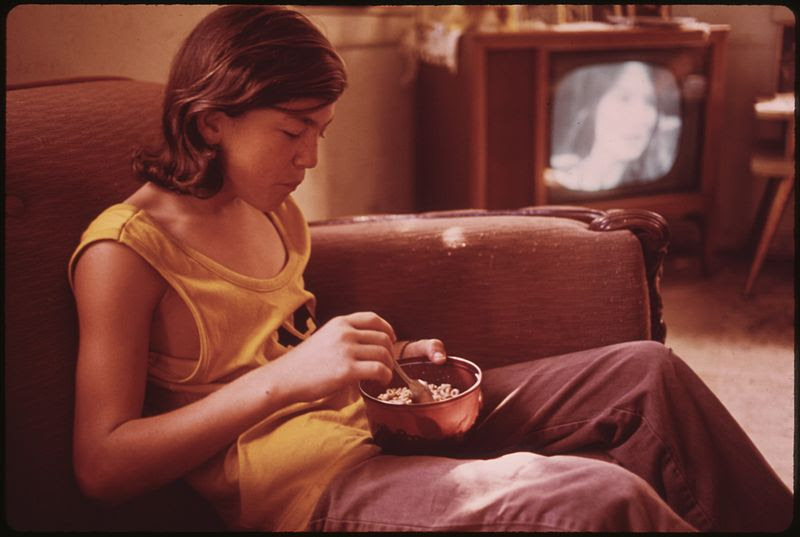 File:BILLY WATKINS EATS A BOWL OF CEREAL IN THE LIVING ROOM OF HIS HOUSE IN MULKY SQUARE. BILLY IS ONE OF 9 CHILDREN OF A... - NARA - 553529.jpg