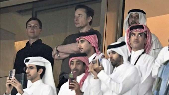 Elon Mush with Jared Kushner visiting with random Arabs in what appears to be a private box in a stadium.