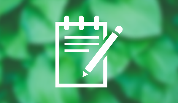 Notepad and pen icon on green blurred background