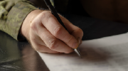 Close-up shot of a veteran filling out a form. 