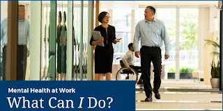 Mental Health at Work – What Can I Do? A man and woman walk down a hallway while another coworker uses a wheelchair in the background.