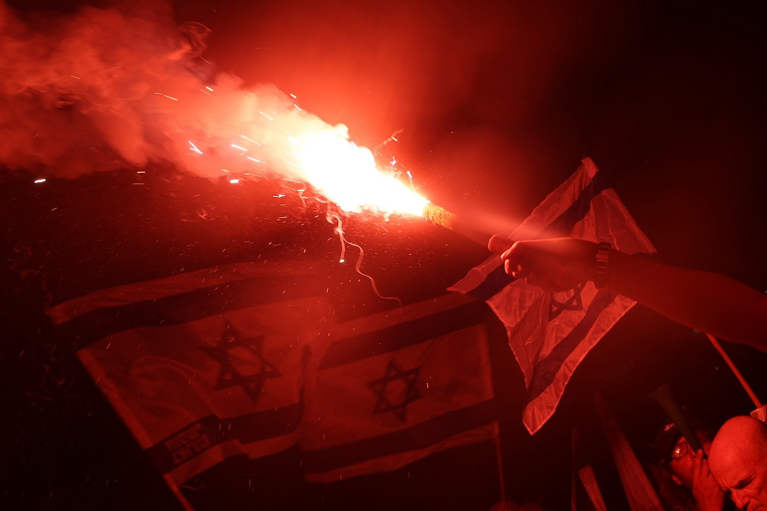 A protester carries a flare during a demonstration against the Israeli government's judicial reform plan in Tel Aviv on July 27.