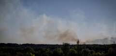 This photograph taken on July 27, 2022 shows smoke from a wildfire rising over a forest, near Vogue, Ardeche, southern France. (Photo by JEAN-PHILIPPE KSIAZEK / AFP)