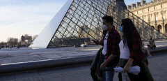 Tourists from Ecuador wearing face mask arrive at the Louvre Museum, in Paris, France, Monday, March 14, 2022. France has lifted most COVID-19 restrictions on Monday, allowing people to remove face masks in almost all places and allowing those unvaccinated back into restaurants, sports arenas and other leisure venues. (AP Photo/Francois Mori)/XFM104/22073678877973//2203141956