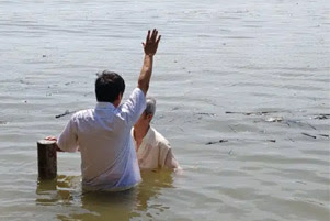 John Cao is baptizing a believer.