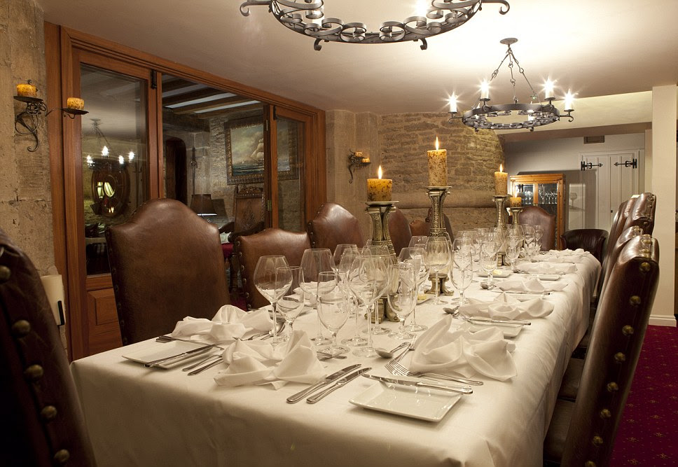 Candles hang from the ceiling and light up the table to give a sense of medieval times at the long dining table in Bath Lodge Castle