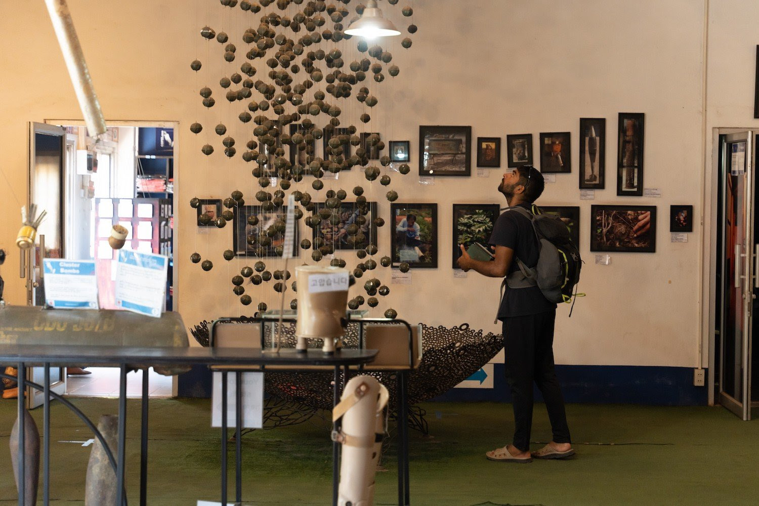 A visitor views an exhibit of cluster bomb remnants at the Cooperative Orthotic and Prosthetic Enterprise Visitor Center in Vientiane, Laos, on July 11.