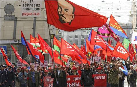 Un simpatizante del Partido Comunista ucraniano con un retrato de Lenin al fondo, durante la celebración del 'Primero de Mayo' en Kharkiv, Ucrania.