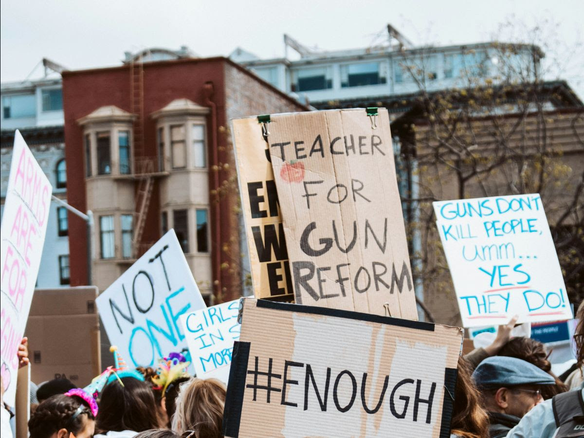 Gun violence protesters hold signs urging the end of nation-wide shootings