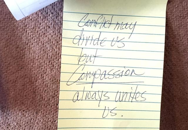 A handwritten notes reads "Conflict may divide us but compassion always unites us."