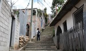 Un niño camina por su barrio Rosalinda, un área de la capital hondureña, Tegucigalpa, conocida por su alto índice de criminalidad.