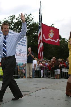 Sen. Rand Paul (R-KY) (L) waves to the crowd while Jenny Beth Martin (R) introduces the next speaker during a Tea Party rally in front of the U.S. Capitol, June 17, 2013 in Washington, DC. The group Tea Party Patriots hosted the rally to protest against the Internal Revenue Service's targeting Tea Party and grassroots organizations for harassment.  