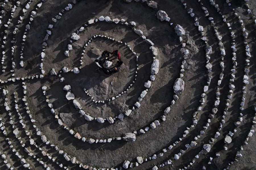 People stand in the center of a rock maze.