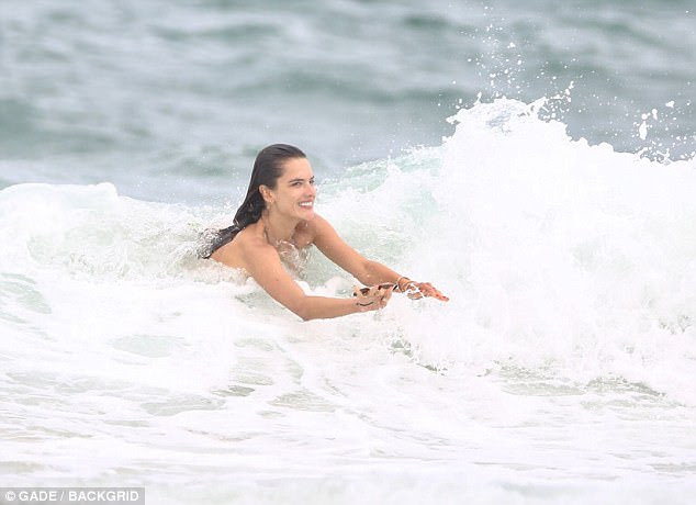 Surfer girl: A beleza nascida no Brasil mostrou sua proeza atlética quando ela montou algumas ondas na costa com um sorriso gigante no rosto 