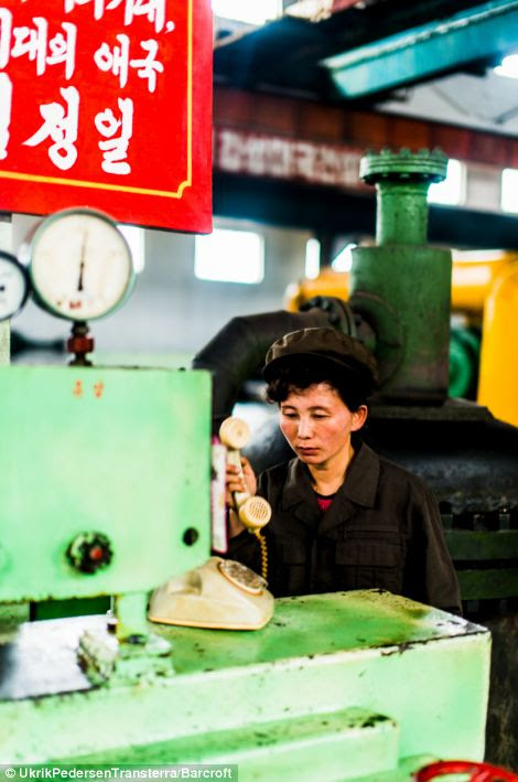 Hardly working? A woman in Hamhung's fertiliser factory answers a very old-fashioned telephone