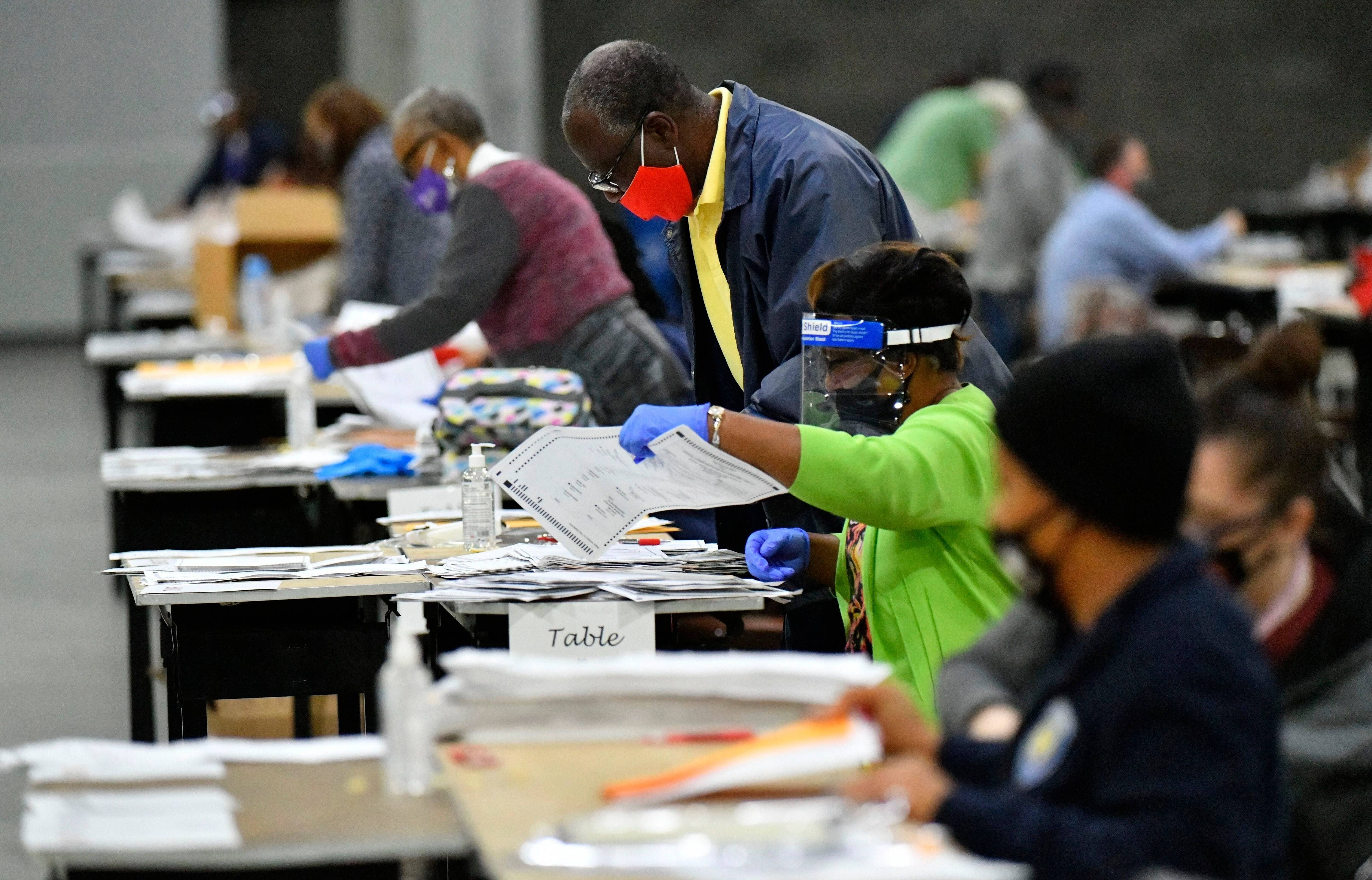 Election workers in Georgia's Fulton County count ballots by hand. (Hyosub Shin/Atlanta Journal-Constitution/AP)