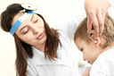 A doctor helping to place a hearing aid on a child.