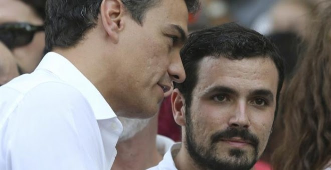 El secretario general del PSOE, Pedro Sánchez (i), conversa con el diputado de IU Alberto Garzón (d), al comienzo del tradicional desfile del Orgullo Gay.- EFE