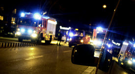 Nighttime photo of emergency medical services racing to disaster