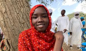 Una niña que huyó de Sudán con su familia espera la distribución de ayuda humanitaria en Chad.