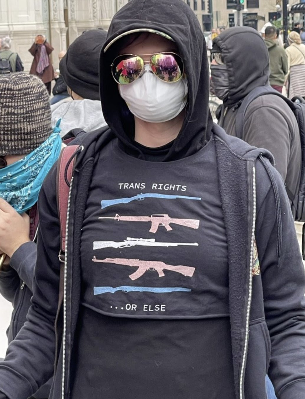 Trans activit wearing popular T-shirt that says "Trans Right or Else# showing 5 assault rifles.