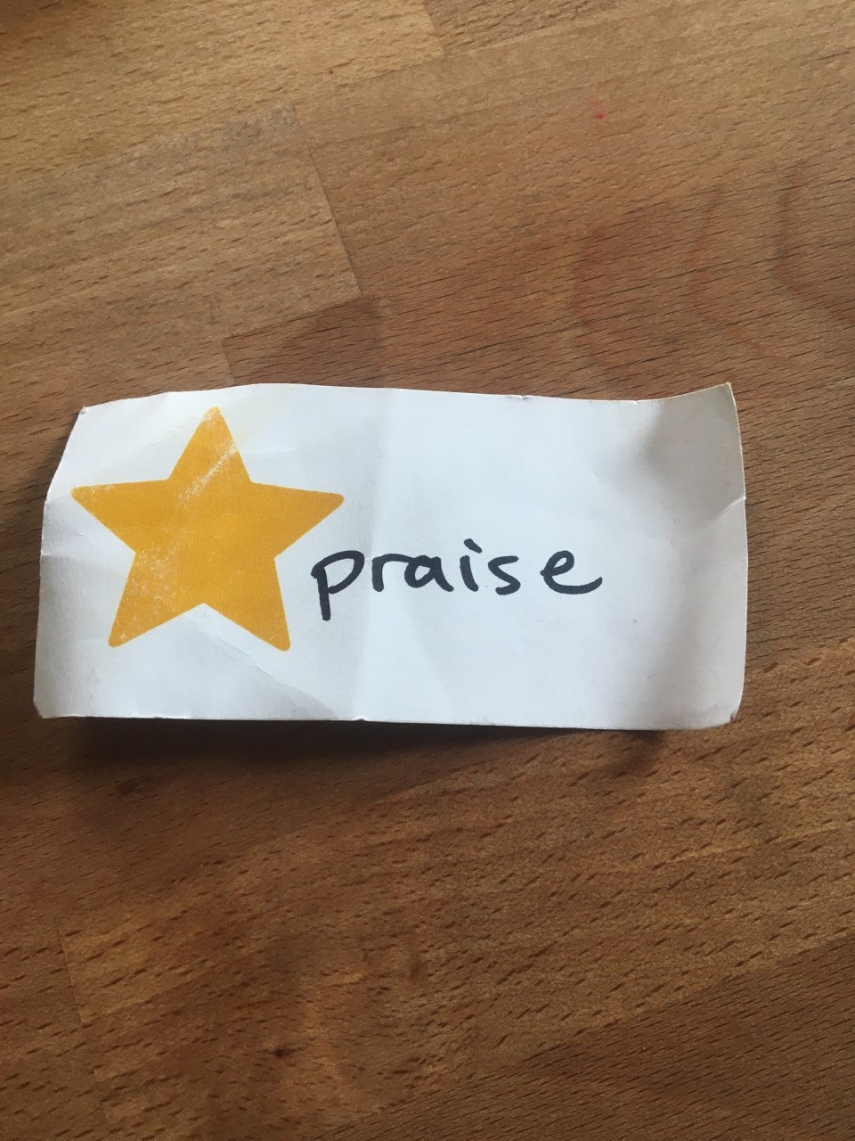 Piece of paper with the word "praise" on it