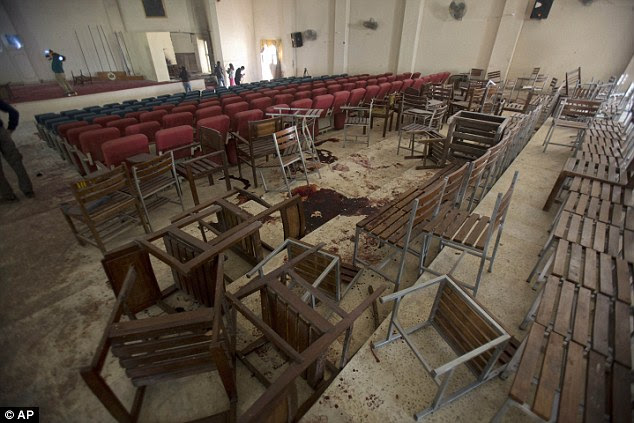 Chairs are upturned and blood stains the floor at the Army Public School auditorium