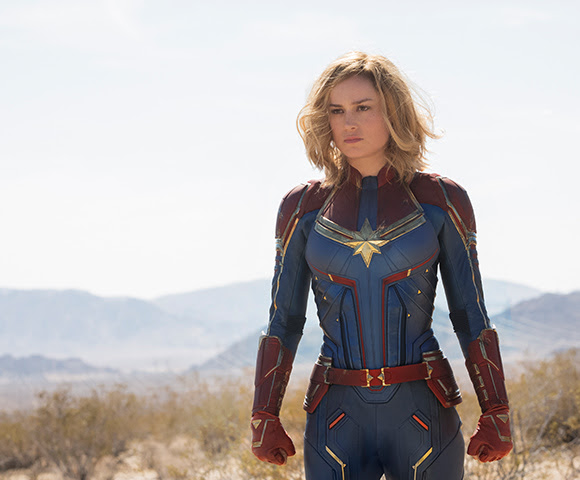 Actress Brie Larson who plays Marvel character Carol Danvers wearing a blue, red and gold body suit.