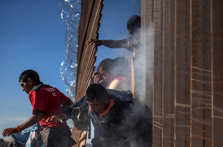 Migrants, part of a caravan of thousands from Central America trying to reach the United States, return to Mexico after being hit by tear gas by U.S. Customs and Border Protection after attempting to illegally cross the border wall into the United States in Tijuana, Mexico, earlier this week.