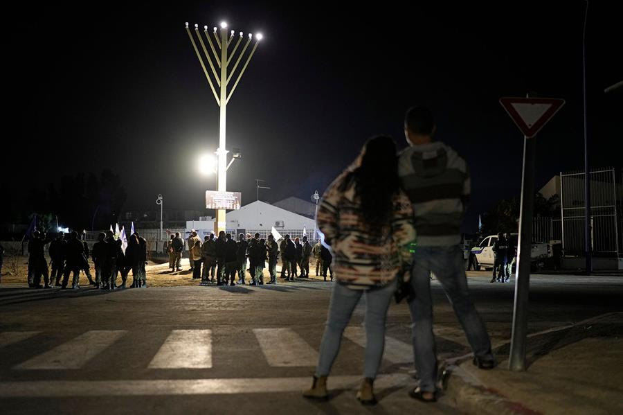 People gather around a menorah lit up for Hanukkah in Sderot, southern Israel.