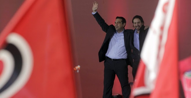 El líder del partido español Podemos, Pablo Iglesias, saluda acompañado por el líder de Syriza, Alexis Tsipras. EFE/Yannis Kolesidis