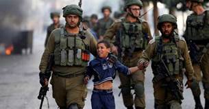 Photo of a young Palestinian child being detained by Israeli forces.