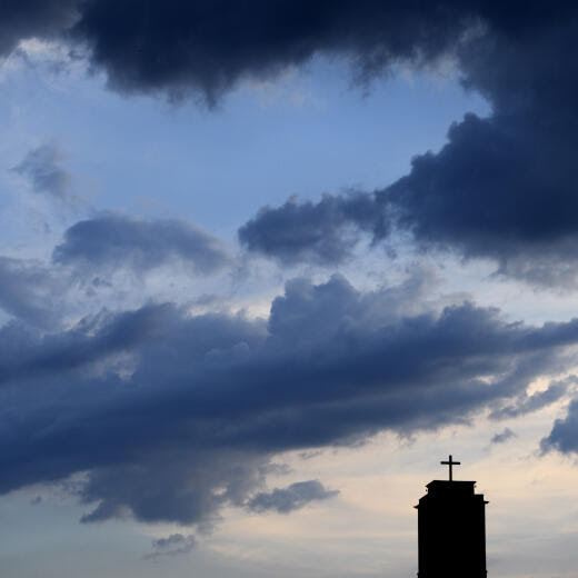 Des nuages et le ciel au soleil couchant sont photographies en dessus du clocher de l' Eglise rouge ce samedi 27 mai 2017 a Neuchatel. (KEYSTONE/Laurent Gillieron)