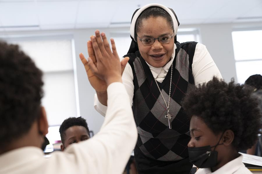 Sister Delphine Okoro, a nun with the Oblate Sisters of Providence, high fives a student as she teaches a fifth grade class at Mother Mary Lange Catholic School in Baltimore, Maryland.