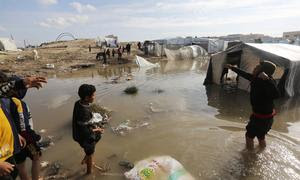 Los desplazados navegan por las aguas de las inundaciones en los campamentos donde viven.