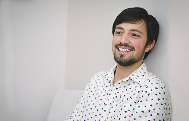 A smiling man with rosacea on his cheeks.