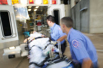 Women on stretcher being put in ambulance by EMTs