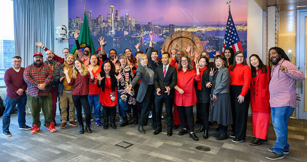 ARTS staff surround their new director making silly faces