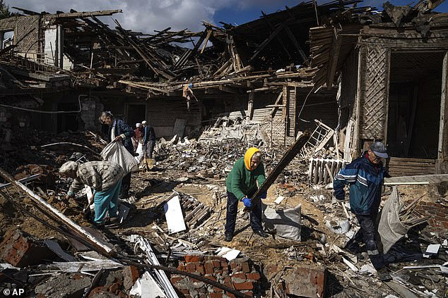 Local residents collect wood for heating from a destroyed school where Russian forces were based