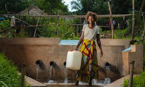 Una mujer recoge agua de una fuente desarrollada por UNICEF en la provincia de Kasai, R.D. Congo.