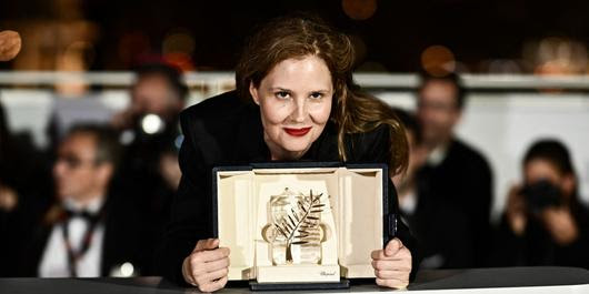 French director Justine Triet poses with her trophy during a photocall after she won the Palme d'Or for the film "Anatomie d'une Chute" (Anatomy of a Fall) during the closing ceremony of the 76th edition of the Cannes Film Festival in Cannes, southern France, on May 27, 2023. (Photo by LOIC VENANCE / AFP)