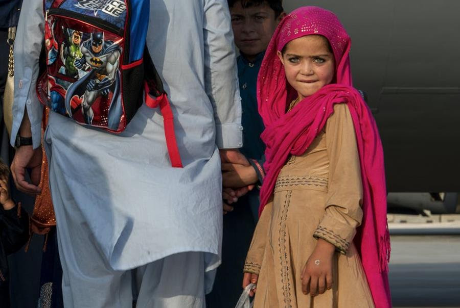 An Afghan girl waits with her family to board a C-17 Globemaster lll on Aug. 22, 2021, at Al Udeid Air Base, Qatar.