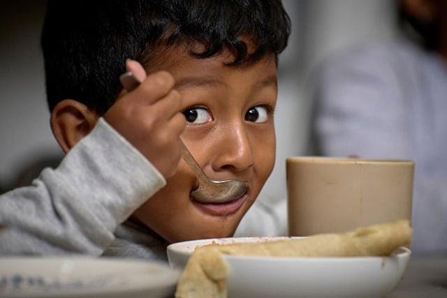 Jaden José Rivas Romero, a 4-year-old boy from Tegucigalpa, Honduras, eats a meal in the Center for Attention to Migrants in Apaxco, Mexico. Photo by the Rev. Paul Jeffrey, UM News.