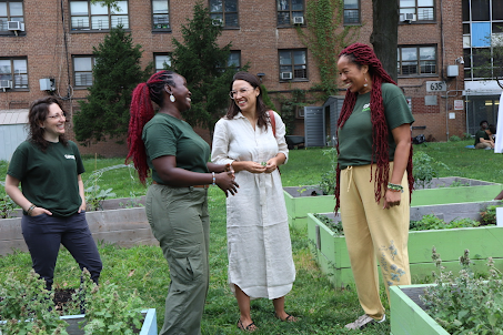 Rep. AOC laughs with 3 constituents in a community garden