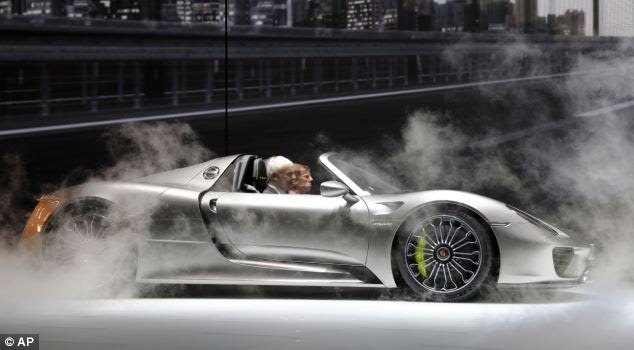 Porsche CEO Matthias Mueller, left, and former rally driver Walter Roehrl show off the 918 hybrid sports car at the motor show