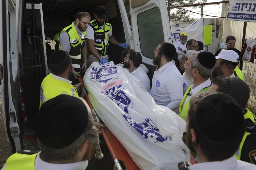 Israeli security officials and rescuers carry a body of a victim who died during a Lag Baomer celebrations, at Mt. Meron in northern Israel.
