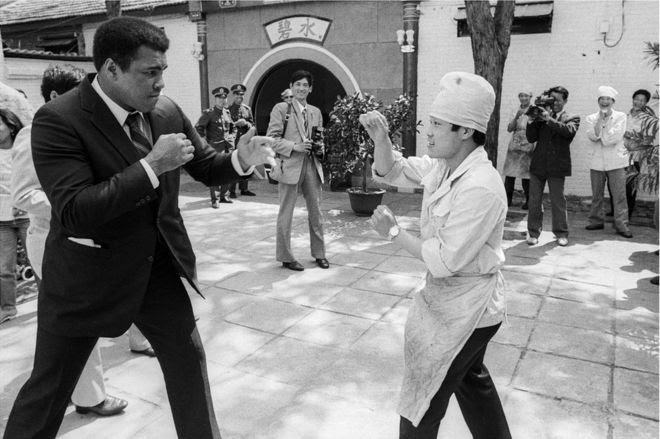 Muhammad Ali sparring with a man in the street